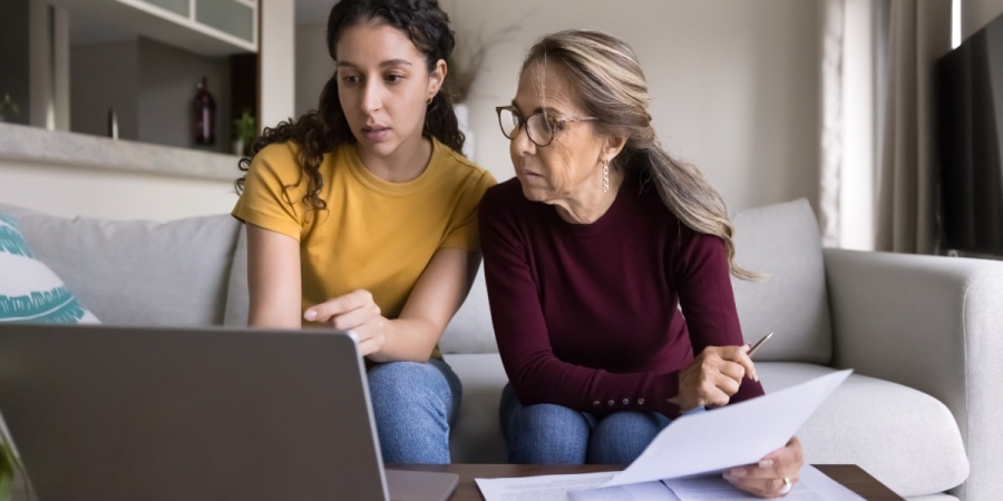 A daughter helping her mother pay a bill online